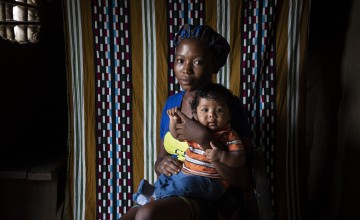 A woman and her baby look at the camera