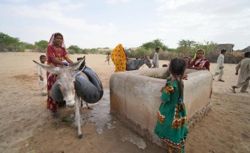 Woman and children collecting water at a well