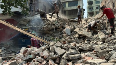 People stand on top of rubbble from the Myanmar earthquake