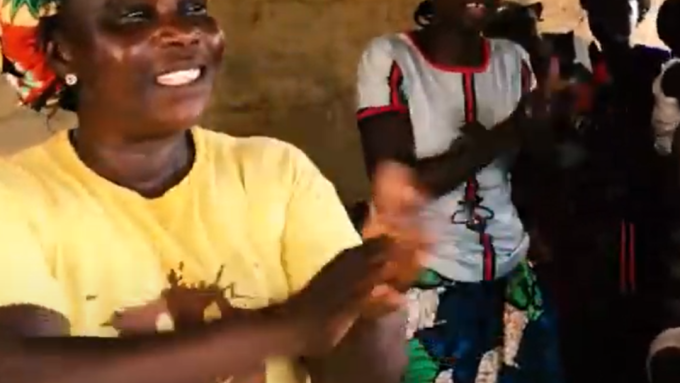A group of women sing and clap